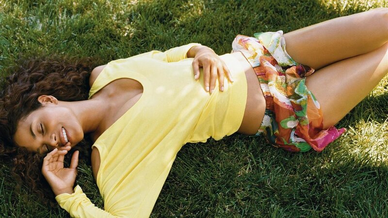 Woman lying on grass in yellow top