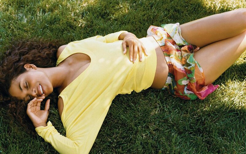 woman lying on grass in yellow top