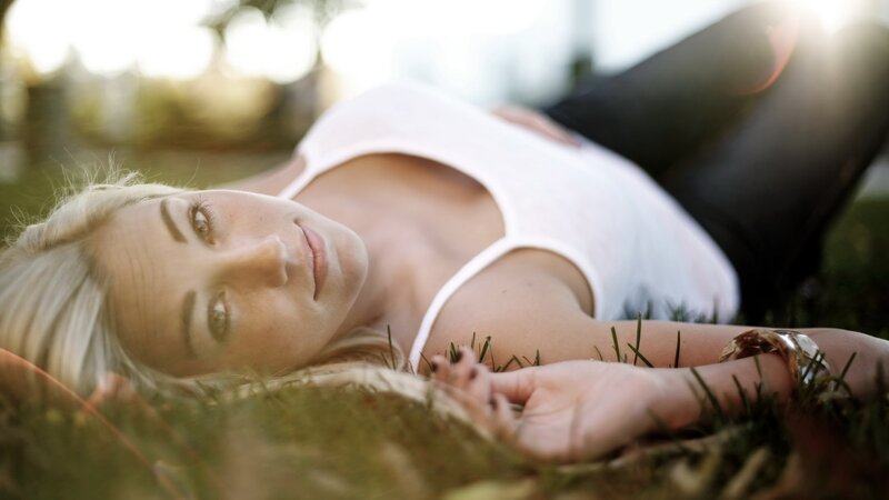 Woman Lying on Grass — White, Serene, Sunset