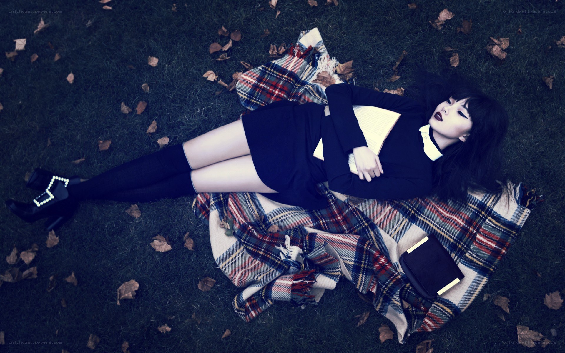 woman lying on grass with book