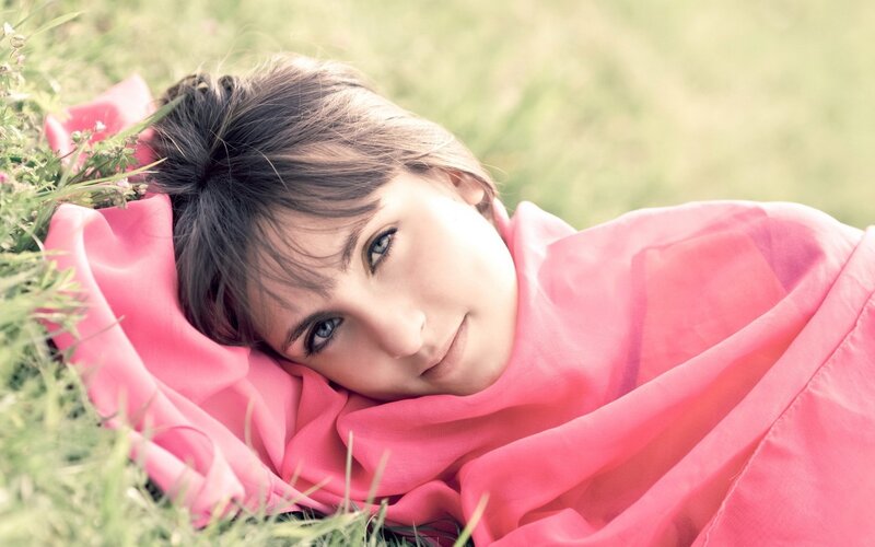 woman lying on grass with pink scarf