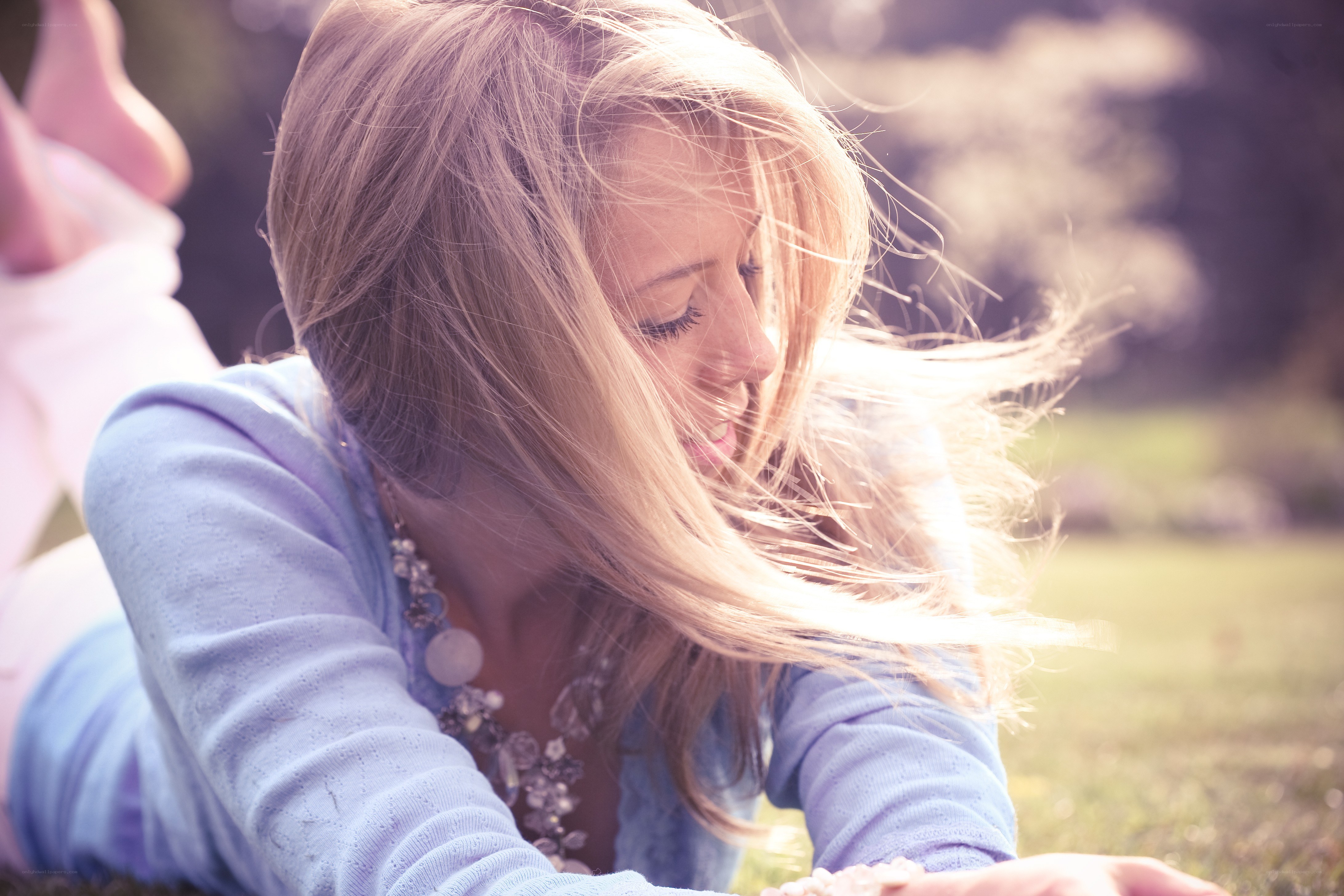 woman lying on grass with wind