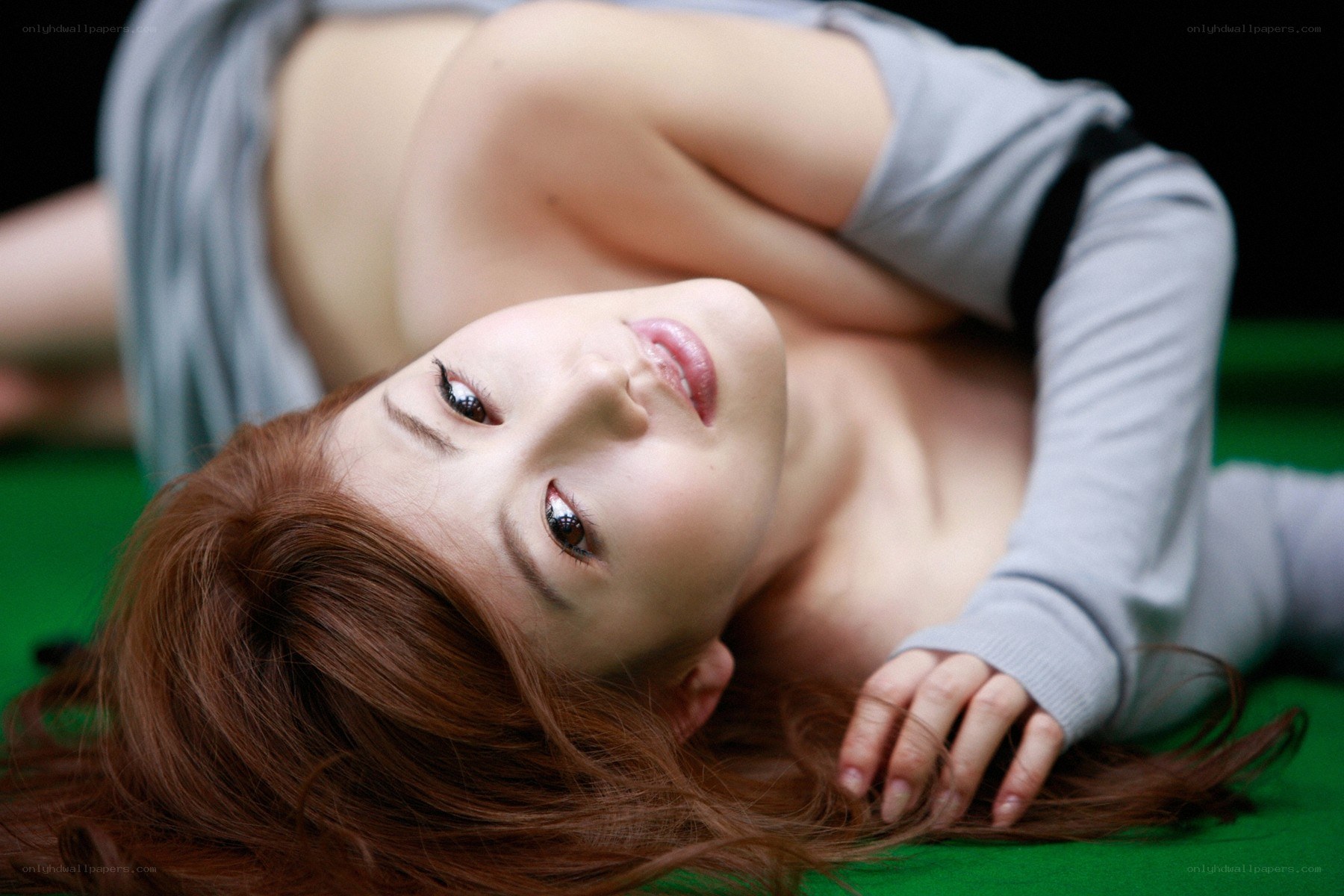 woman lying on green surface