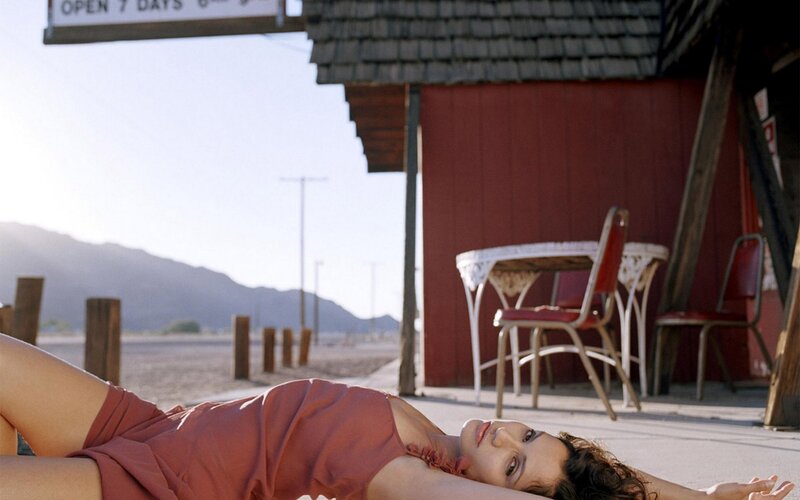 woman lying on ground in desert
