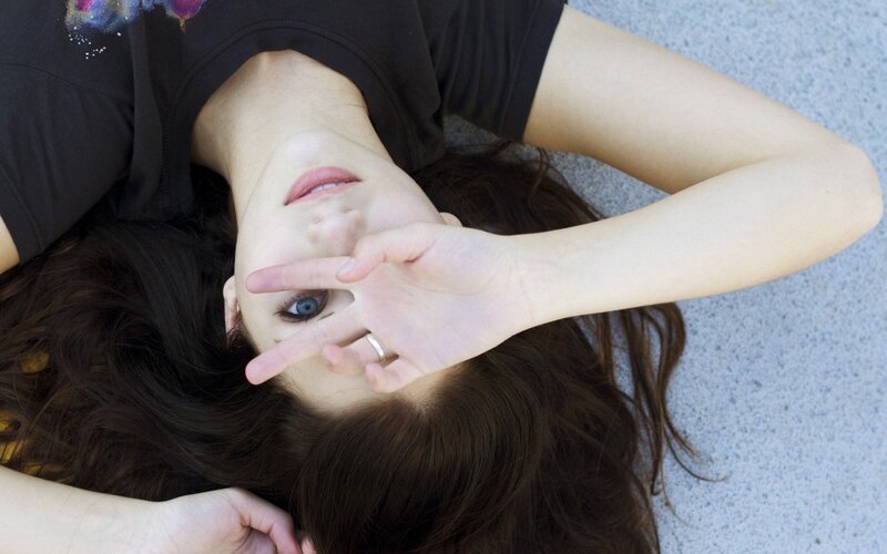 woman lying on ground making peace sign