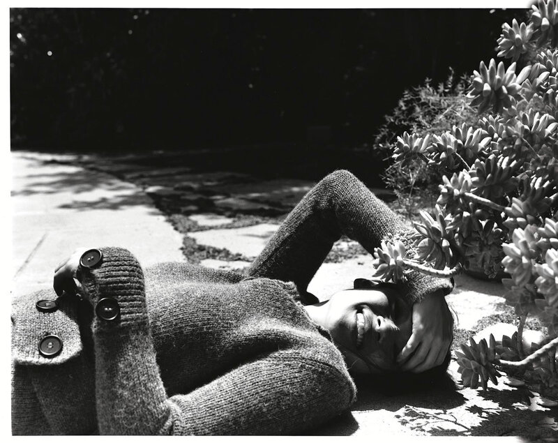 Woman lying on ground with plant