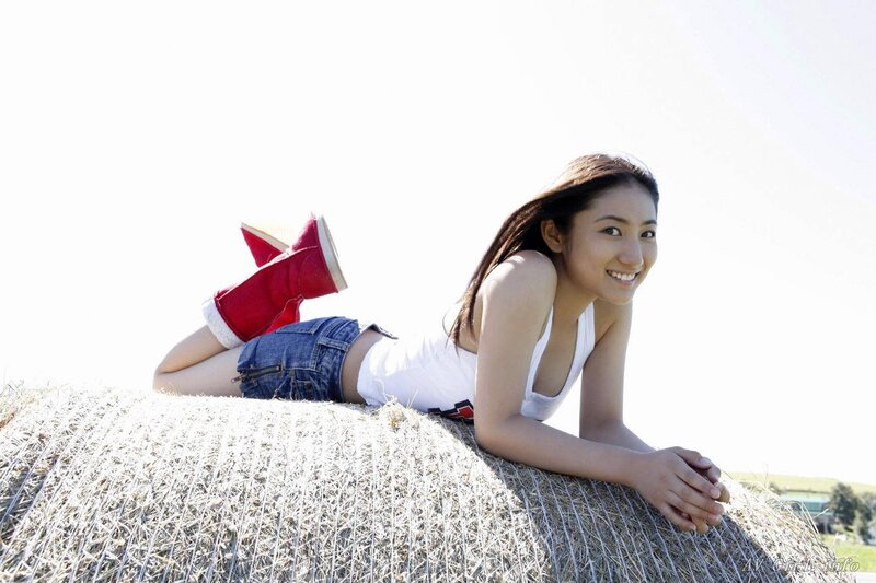 Woman lying on hay bale