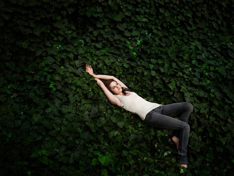 woman lying on ivy wall