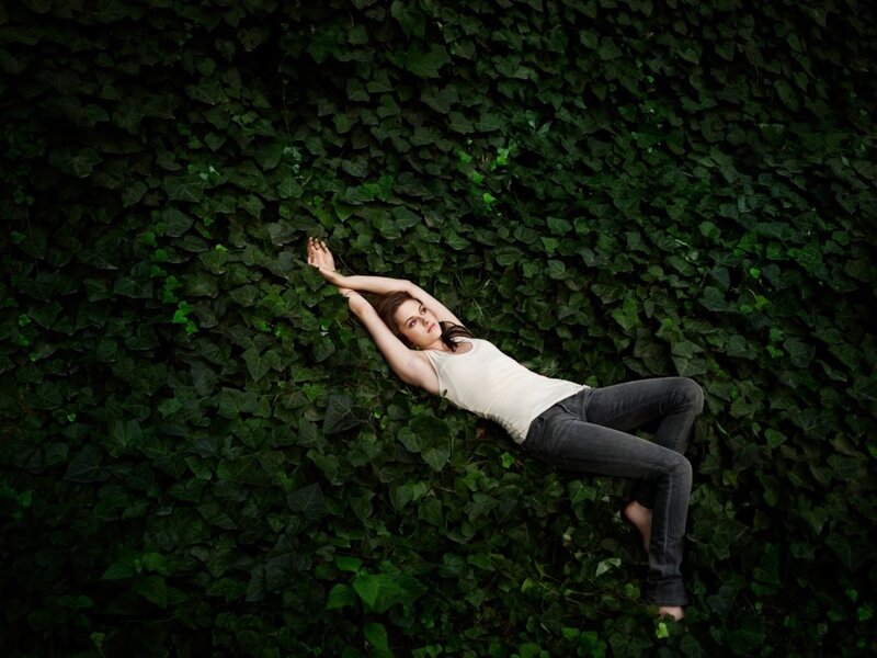 woman lying on ivy wall
