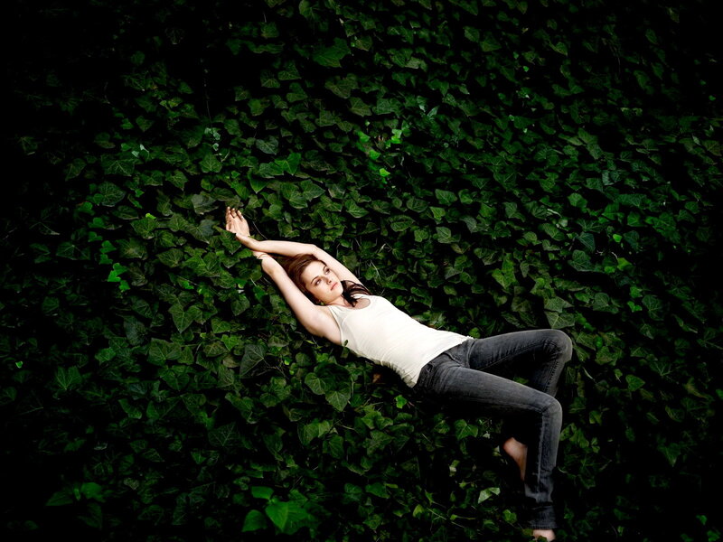 woman lying on ivy wall