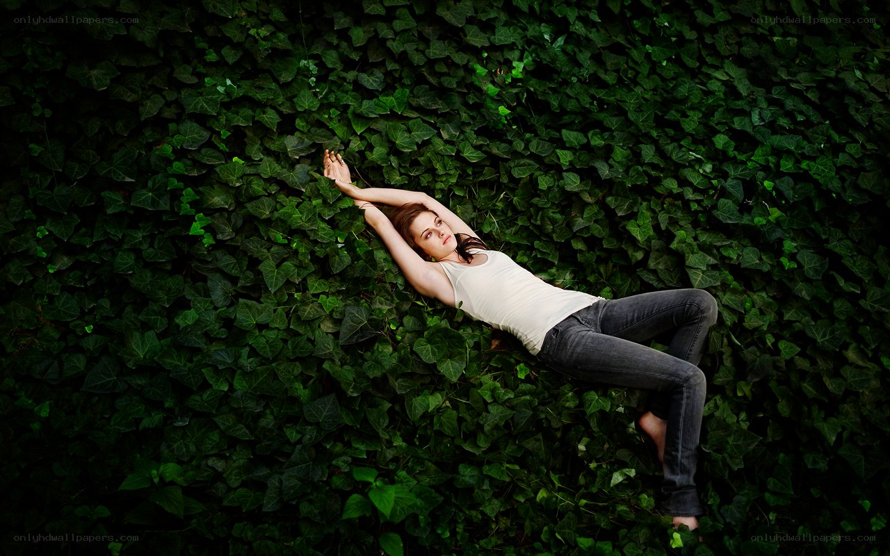 woman lying on ivy wall