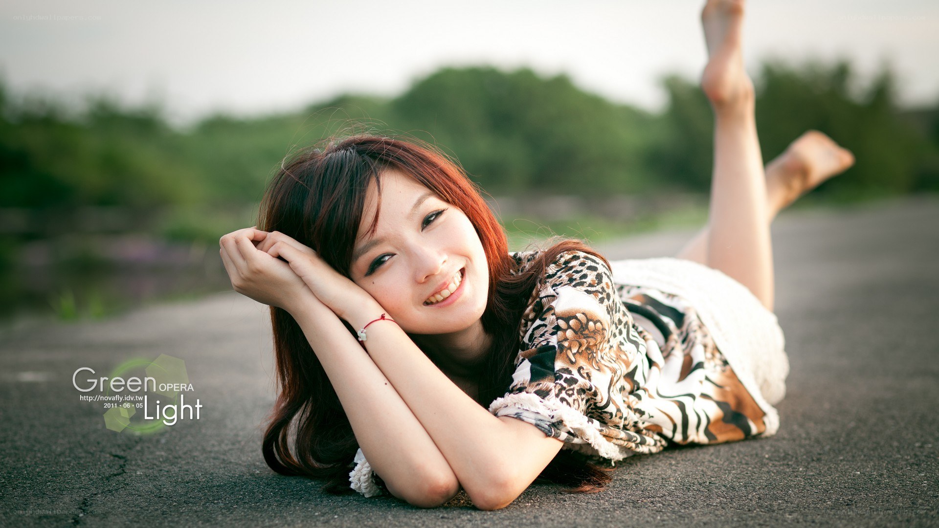 woman lying on pavement smiling