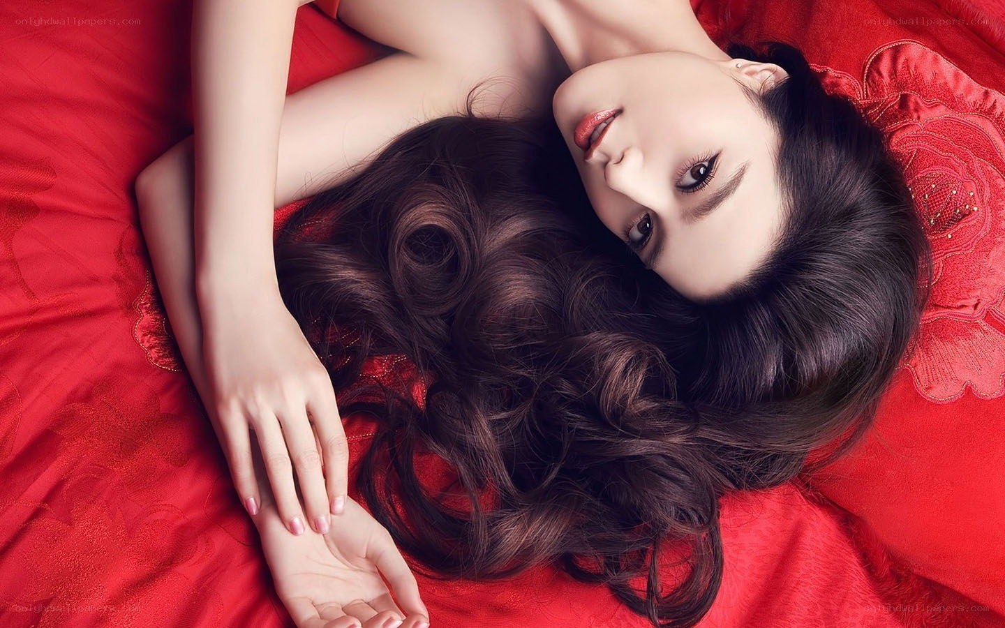 woman lying on red bed