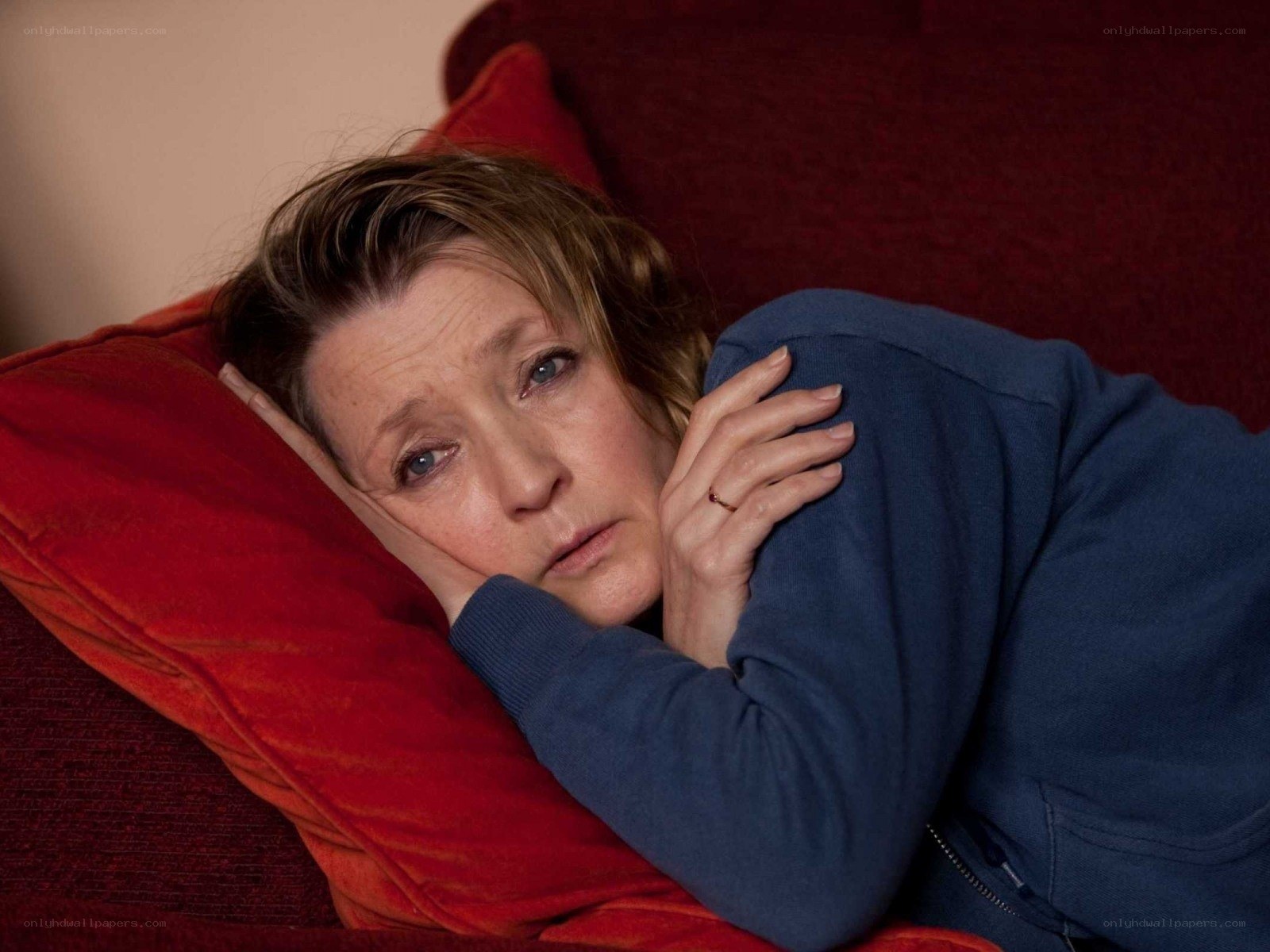 woman lying on red couch
