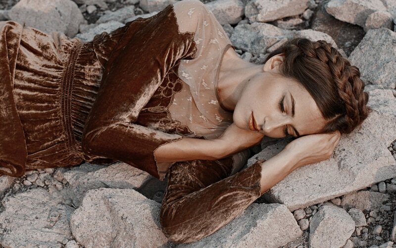 Woman Lying on Rocks — Brown, Serene