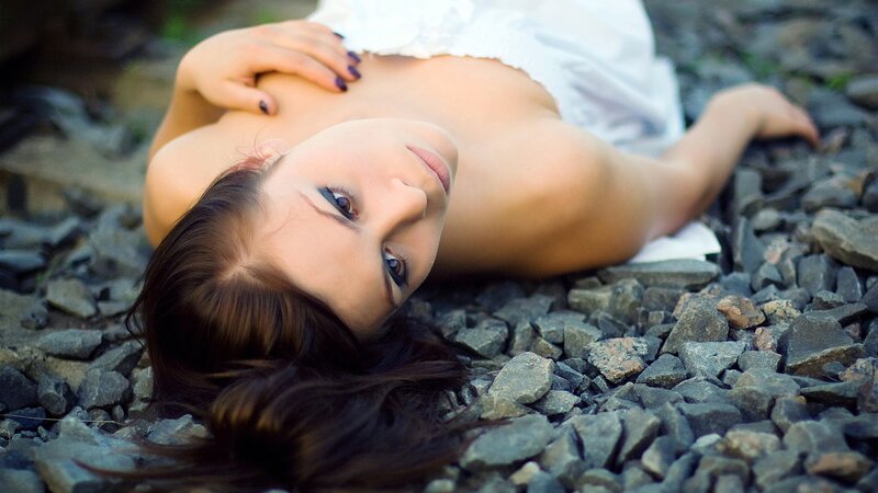 woman lying on rocky ground