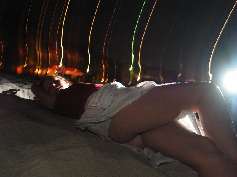 Woman lying on sand at night