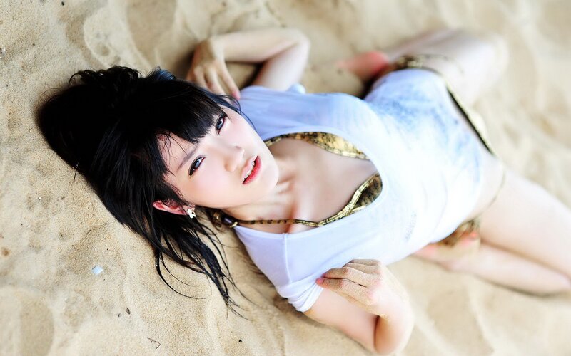woman lying on sandy beach