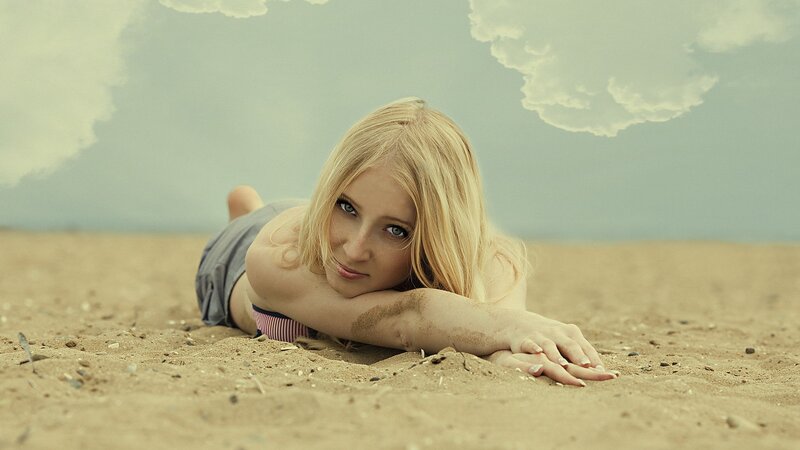 woman lying on sandy beach