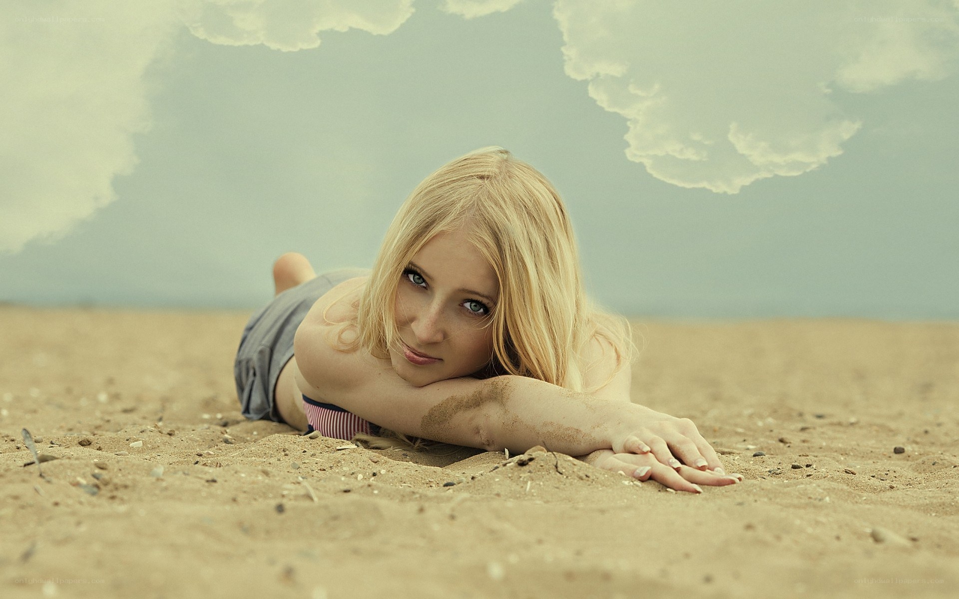 woman lying on sandy beach