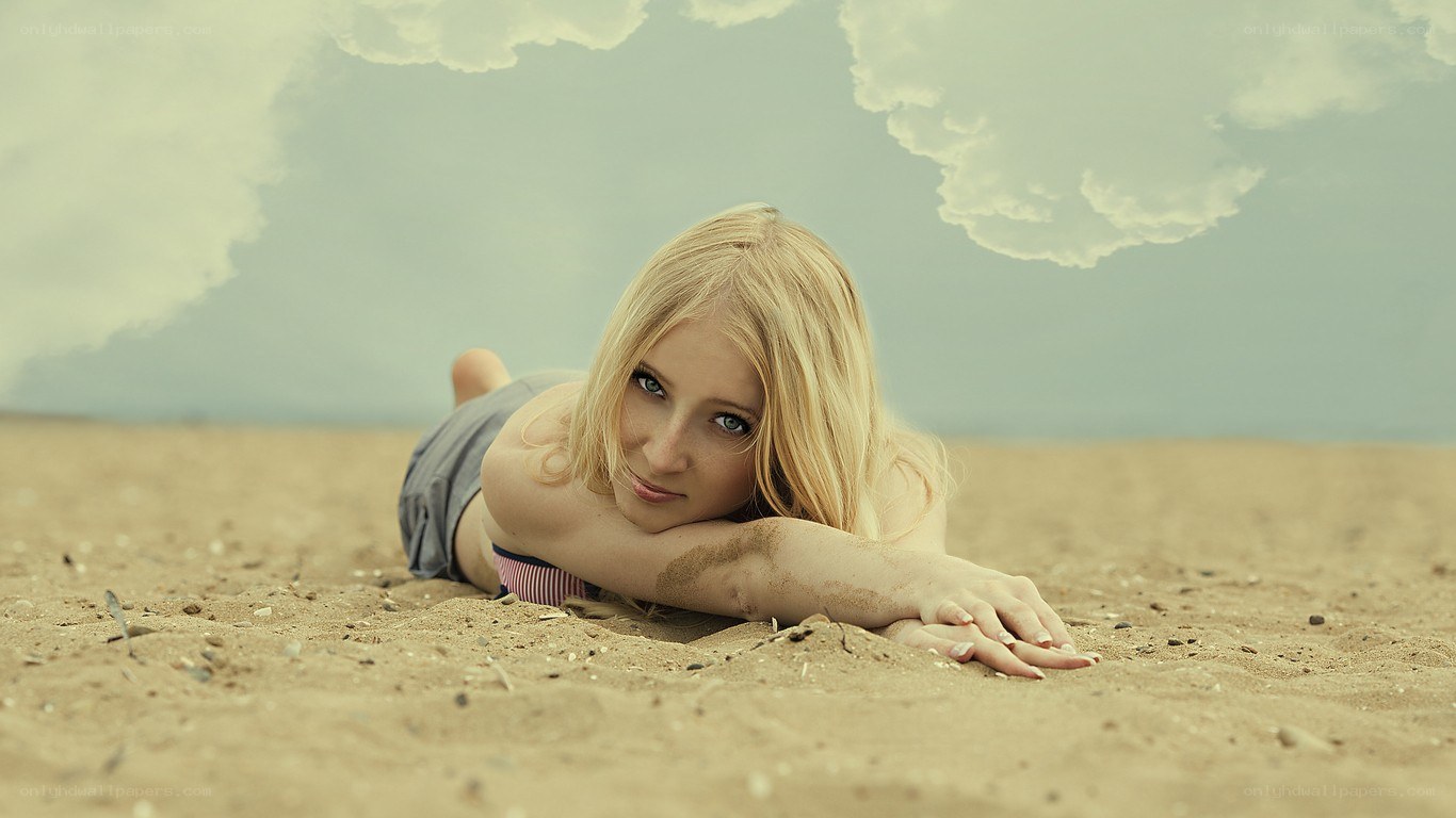 woman lying on sandy beach