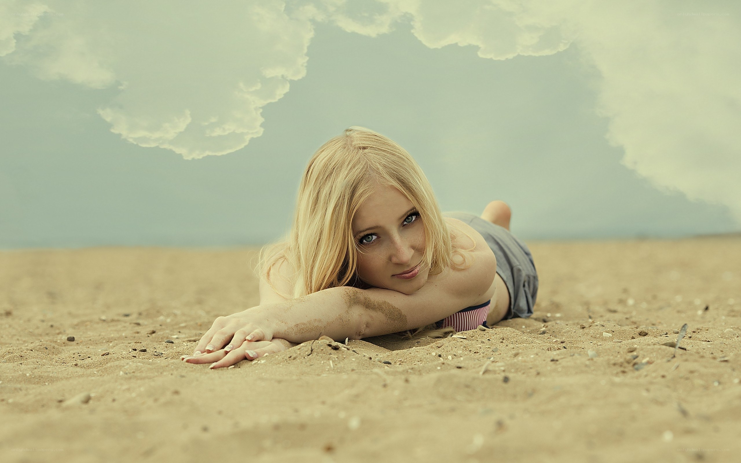 Woman lying on sandy beach