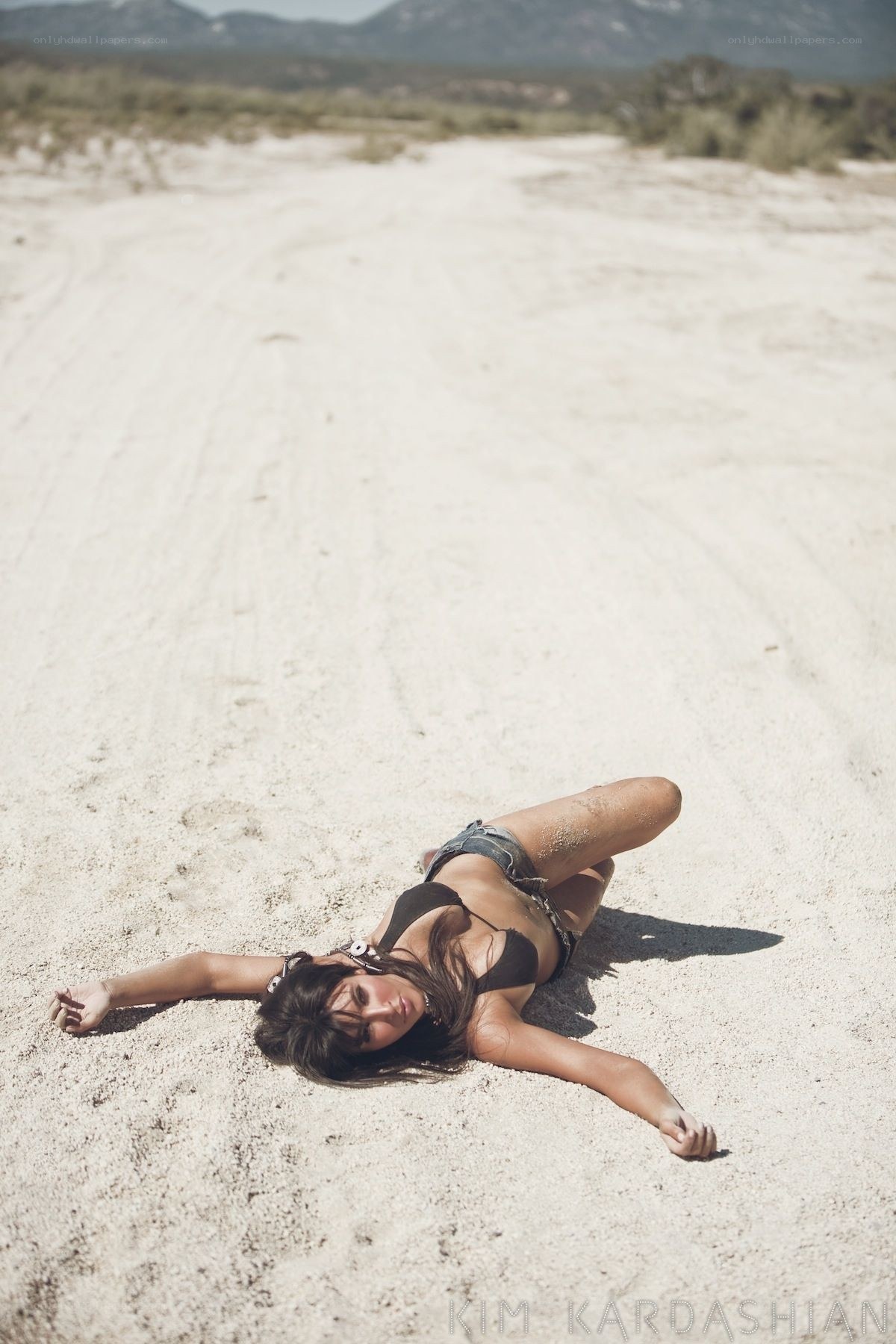 woman lying on sandy ground