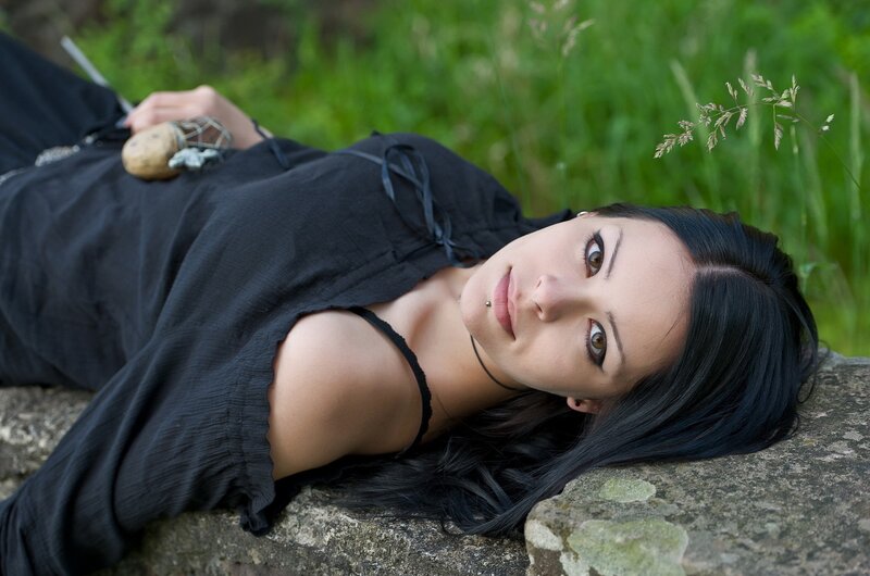 woman lying on stone in grass