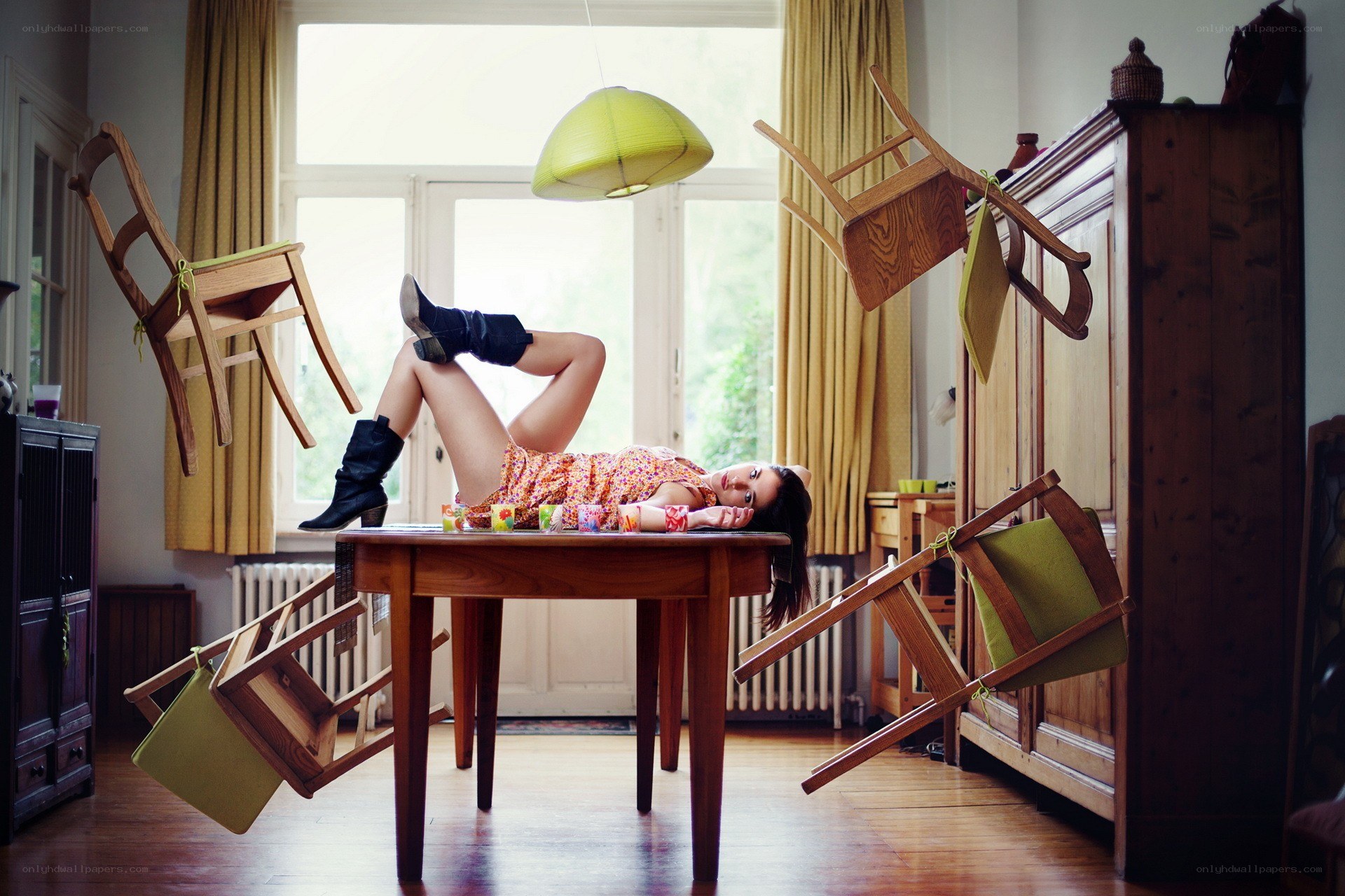 woman lying on table with floating chairs