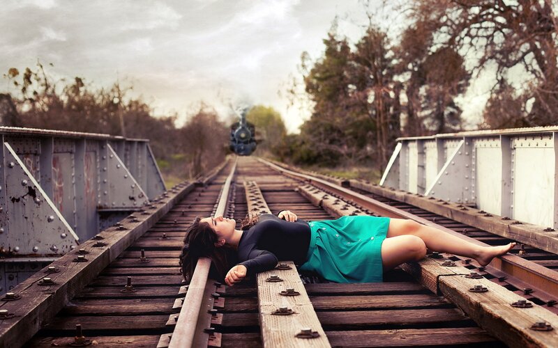 Woman lying on train tracks