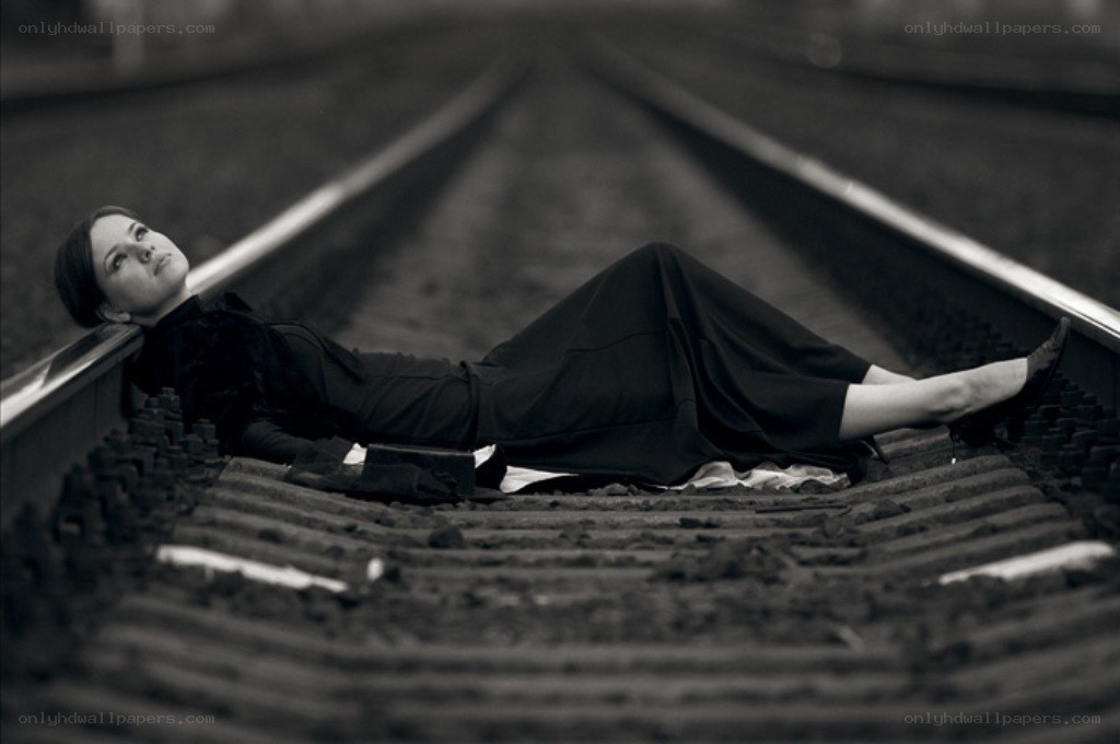 Woman lying on train tracks
