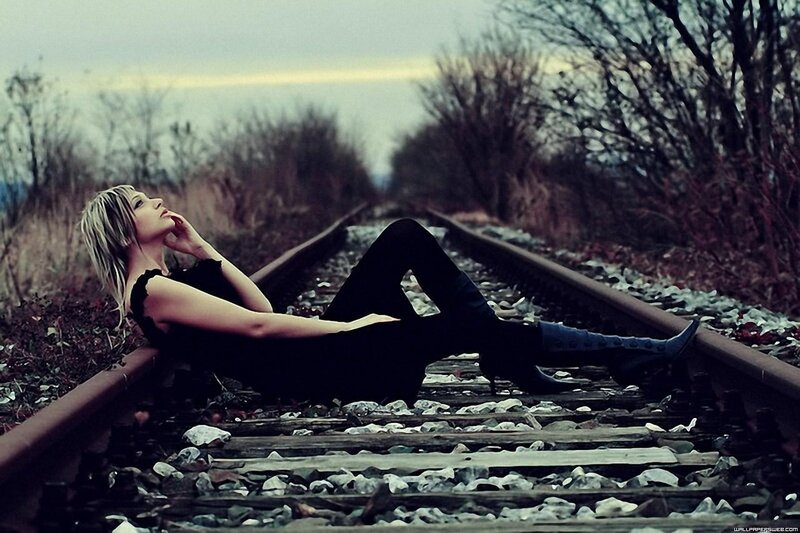 woman lying on train tracks