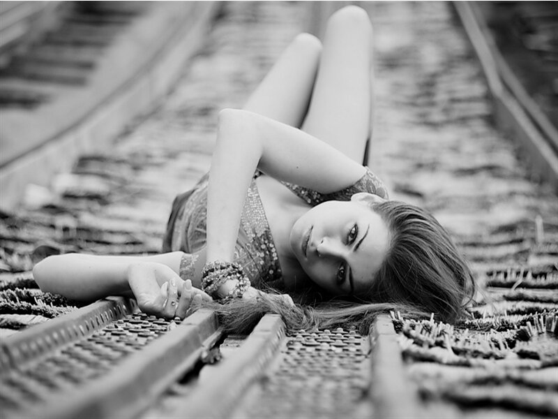 Woman Lying on Train Tracks — Black, Dramatic, Photograph