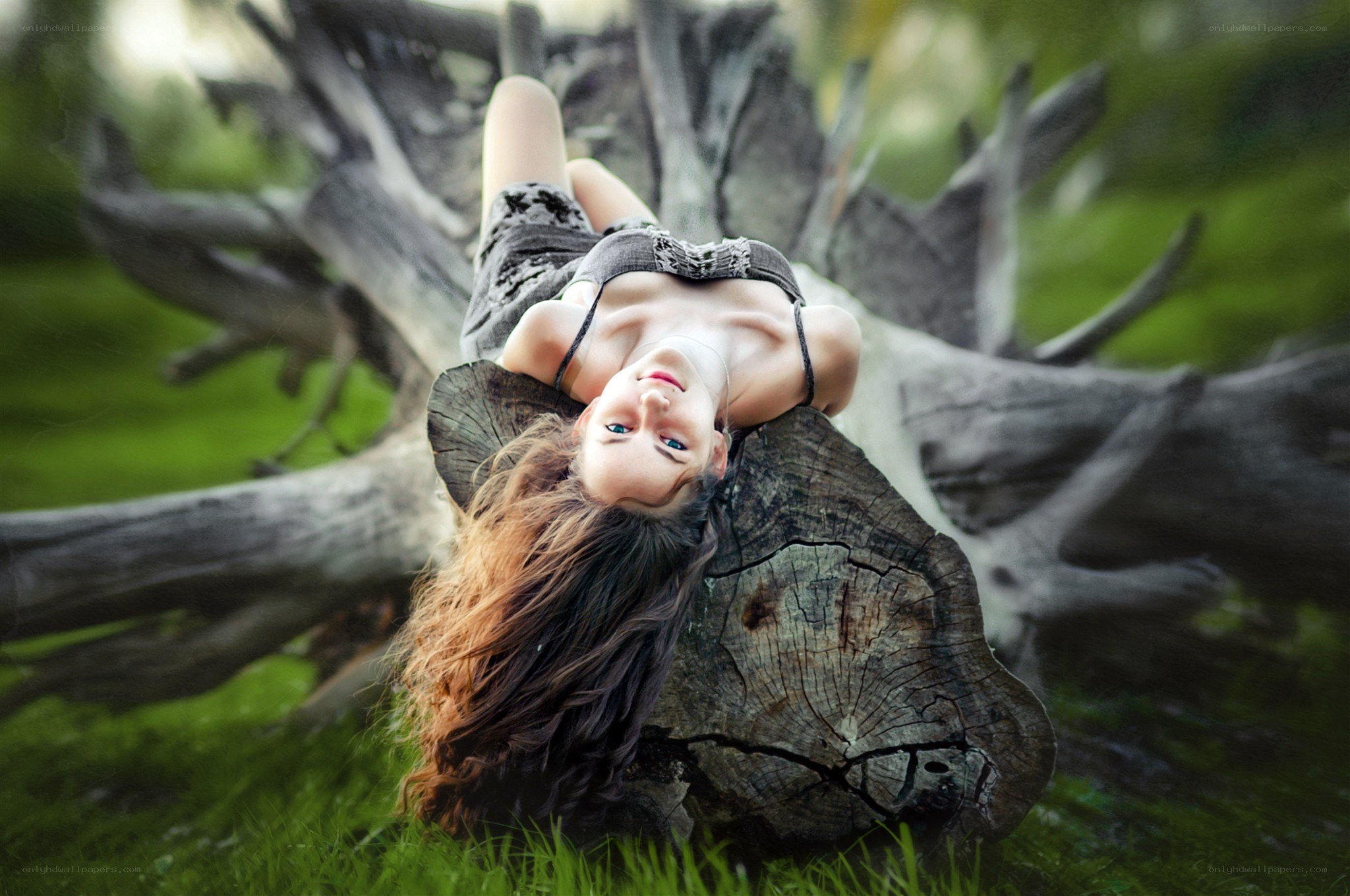 woman lying on tree stump