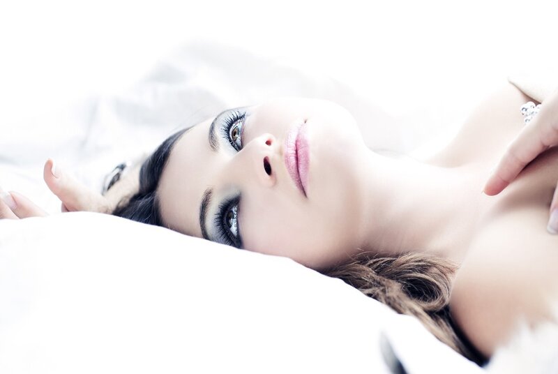 woman lying on white bed