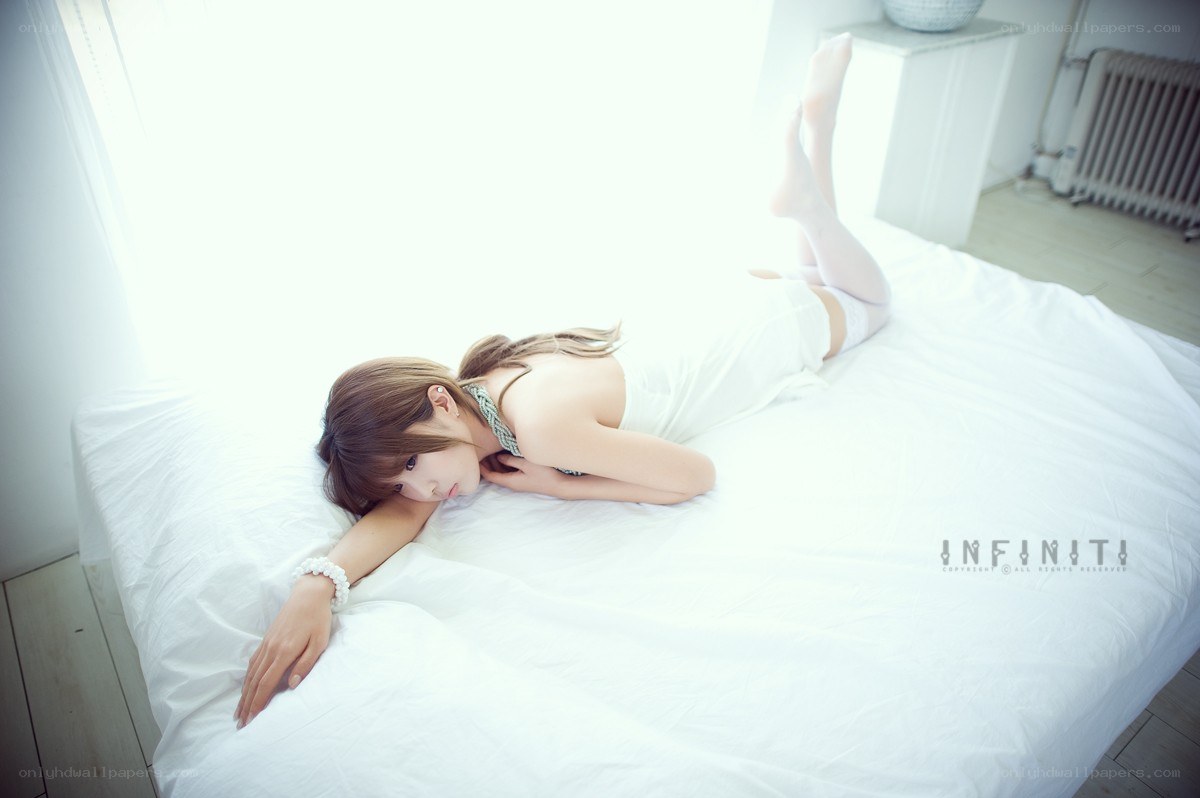 woman lying on white bed