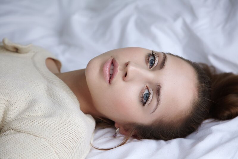 woman lying on white bed