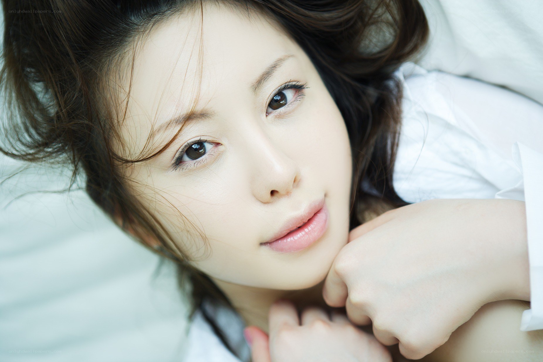 woman lying on white bedding