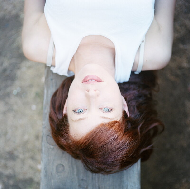 woman lying on wooden bench