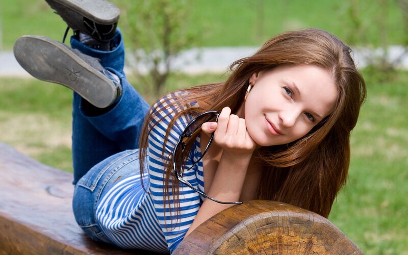 woman lying on wooden bench