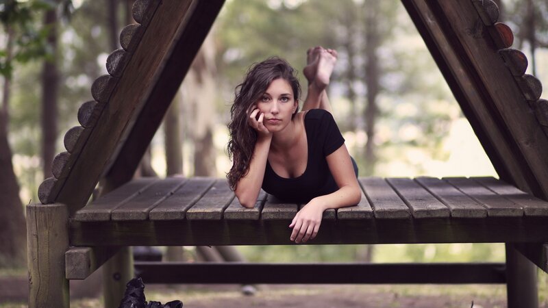 woman lying on wooden bench