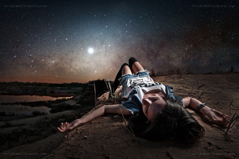 Woman lying under starry sky