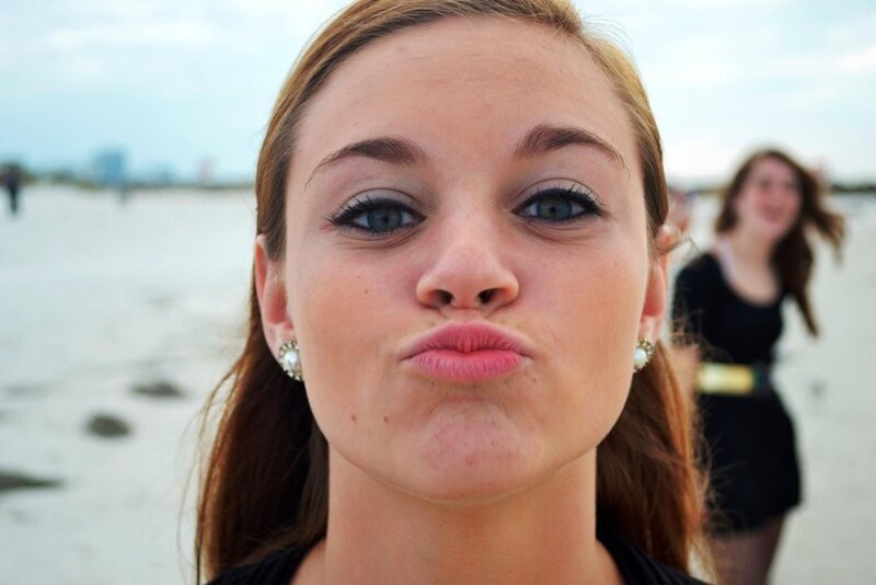 woman making a kissy face at the beach