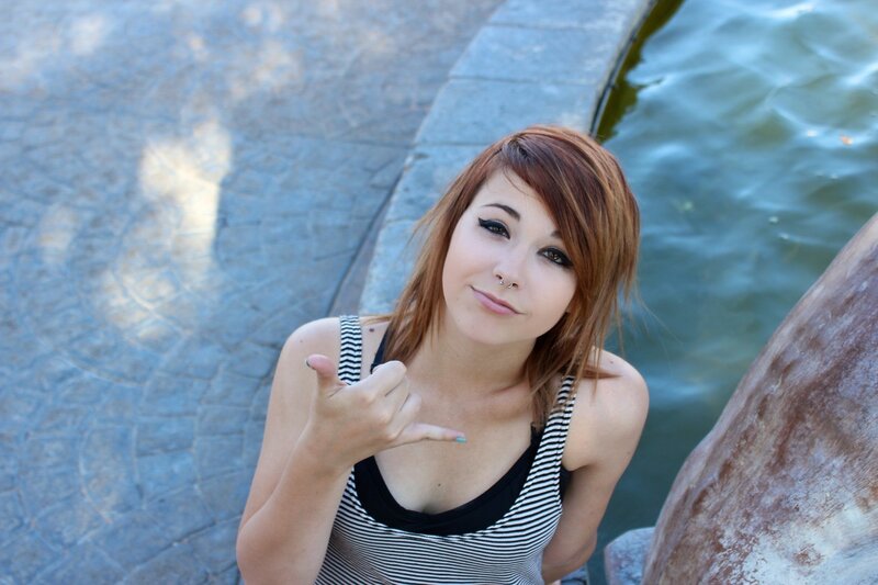 woman making hand gesture by water