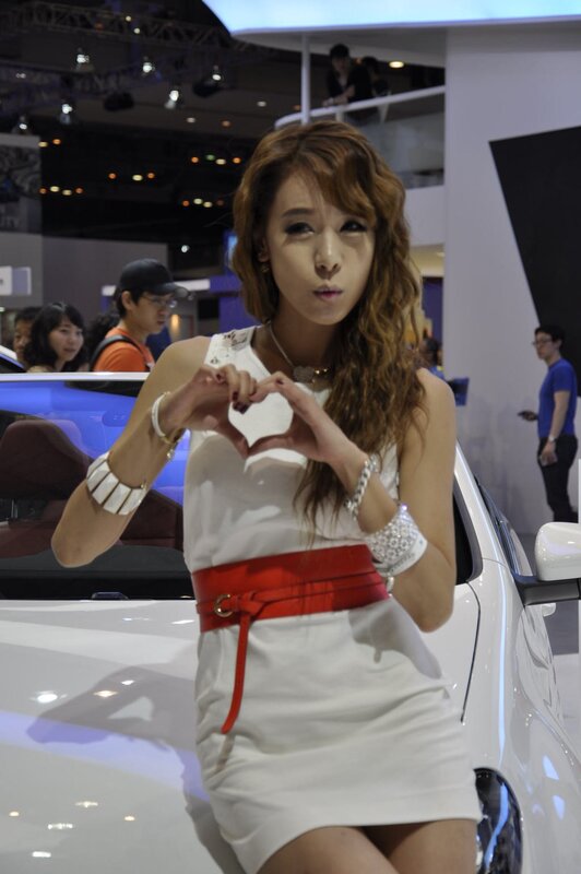 Woman making heart gesture at auto show