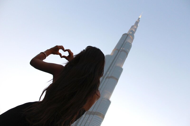 Woman making heart shape near Burj Khalifa