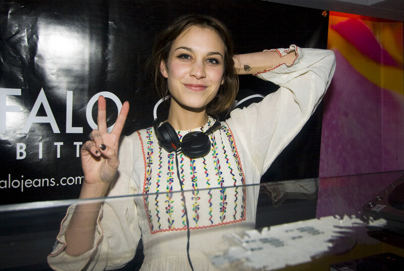 woman making peace sign at event