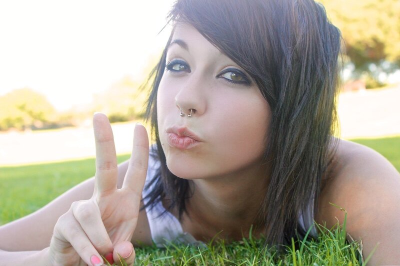 woman making peace sign on grass