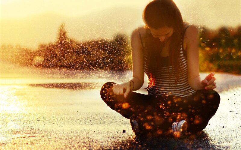 woman meditating at sunset