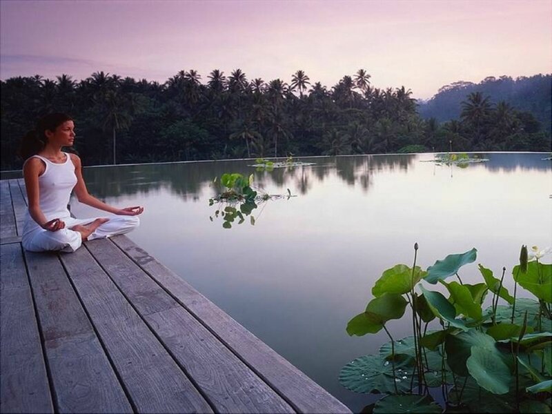 Woman meditating by a lake